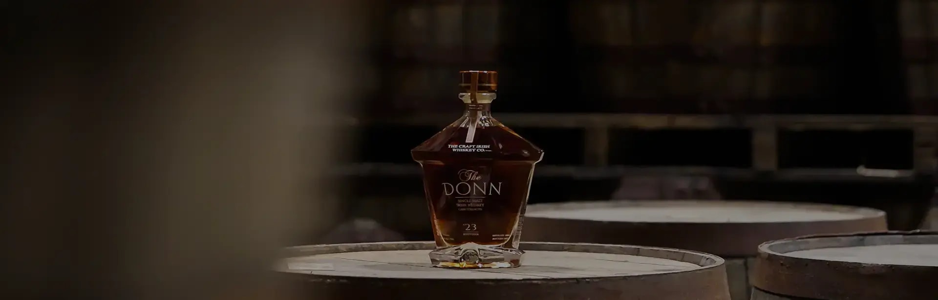 A bottle of The Donn resting on a maturing cask